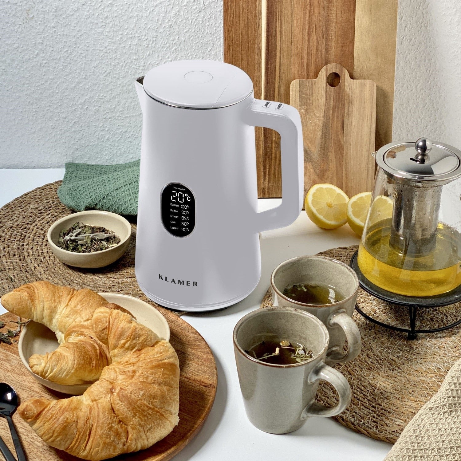 Wasserkocher 1.5 Liter in elegantem Design mit Teetassen und Croissant auf einem gedeckten Tisch.
