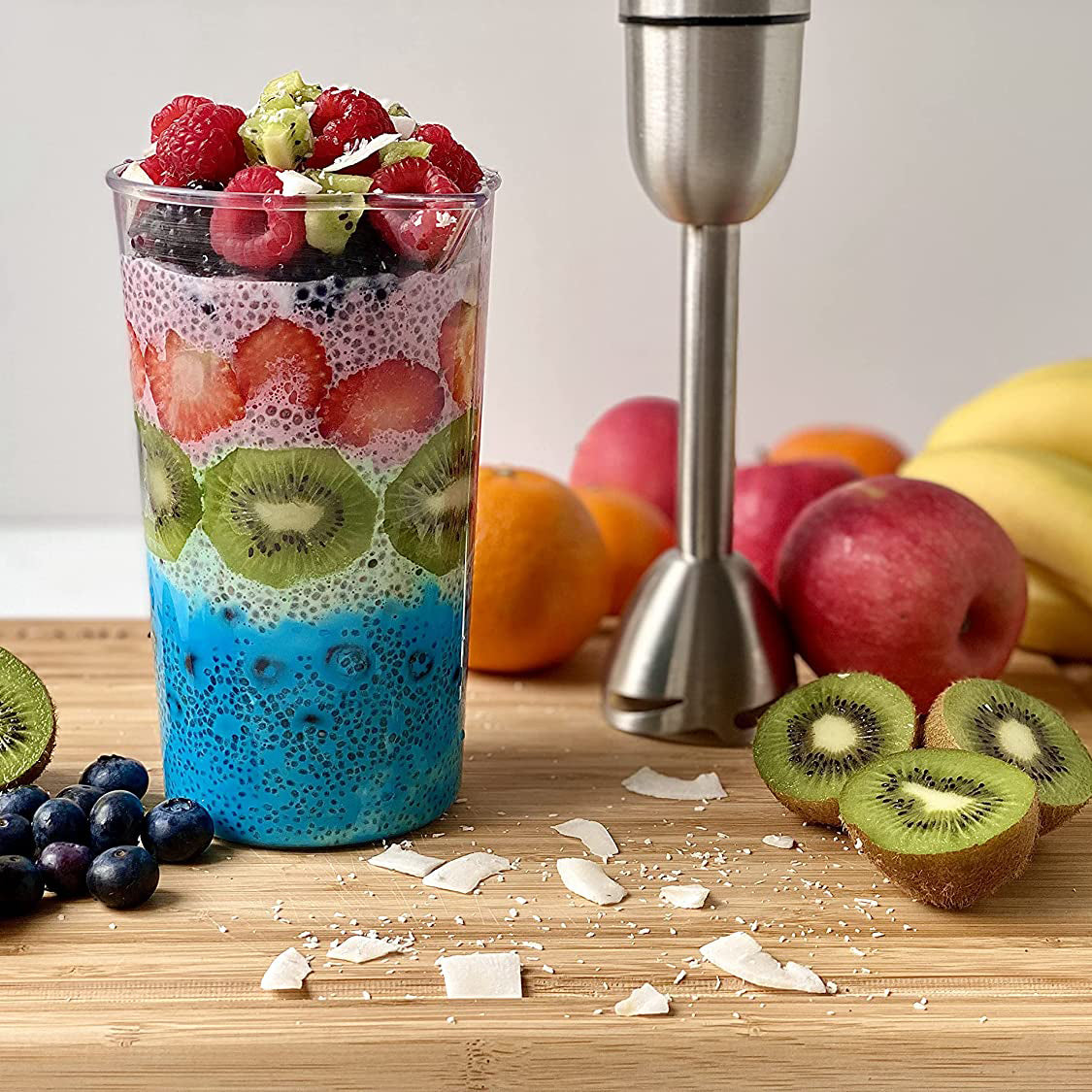 Stabmixerset 4-teilig 800 Watt mit buntem Smoothie, frischem Obst und Stabmixer auf einem Holzbrett.