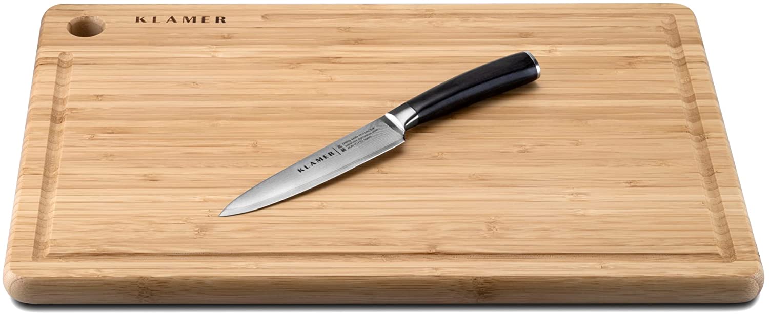 Damast Allzweckmesser 13.7cm auf einem Holzschneidebrett mit Klamer-Logo