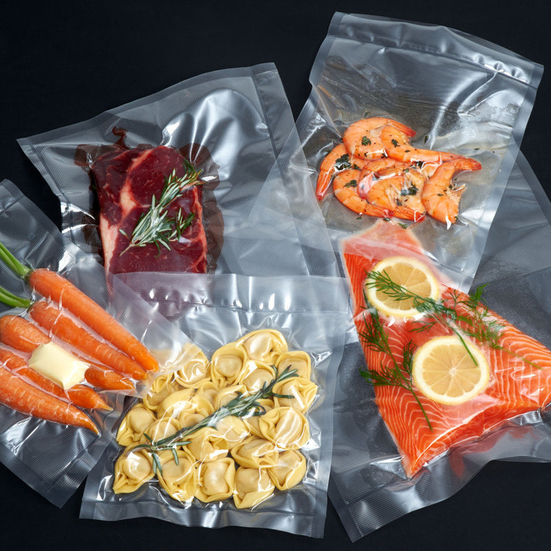 Vakuumierer Vacuum Pro 80 sealing various foods like fish, meat, vegetables, and pasta in vacuum bags.